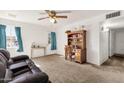 Open-concept living room with neutral carpet, desk, and a ceiling fan at 5517 N 61St Ln, Glendale, AZ 85301