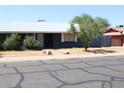 A well kept single story home featuring minimal desert landscaping and a white roof at 6319 E Albany St, Mesa, AZ 85205