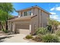 Side view of a two-story home with a two-car garage, neutral paint, and low-maintenance landscaping at 7650 E Williams Dr # 1038, Scottsdale, AZ 85255