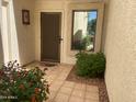 Inviting front porch with tiled flooring, window, and lovely landscaping create a warm entry at 9734 W Kerry Ln, Peoria, AZ 85382