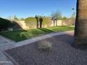 Manicured backyard featuring lush green grass, stone pathway, and well-maintained landscaping at 10249 N 58Th Pl, Paradise Valley, AZ 85253