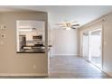 Bright living room with ceiling fan, wood look tile floors and access to kitchen with black counters at 1118 N Granite Reef Rd, Scottsdale, AZ 85257