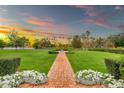 Expansive property featuring a brick path that runs through a beautifully manicured lawn with mature trees, hedges, and flowerbeds at 12 E Oakwood Hills Dr, Chandler, AZ 85248
