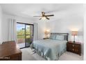 Bright main bedroom features a ceiling fan, neutral carpet, and sliding glass doors to a private balcony at 14645 N Fountain Hills N Blvd # 215, Fountain Hills, AZ 85268