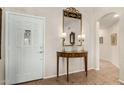 Traditional entryway with decorative mirror, lamps, and console table, next to a white front door at 15460 W Merrell St, Goodyear, AZ 85395