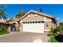 Close-up of the garage door and front of the house, highlighting the desert landscaping at 15460 W Merrell St, Goodyear, AZ 85395
