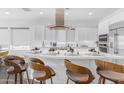 Modern kitchen featuring a large island with seating, stainless steel appliances, and elegant white cabinetry at 187 E Santa Lucia Ln, Queen Creek, AZ 85140
