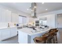 Modern white kitchen with a large island, stainless steel appliances, and countertop dining at 187 E Santa Lucia Ln, Queen Creek, AZ 85140