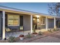 Inviting porch with stylish seating, desert plants, and a brick walkway leading to the front door at 2140 W Mitchell Dr, Phoenix, AZ 85015