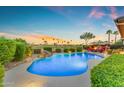 Inviting pool with waterfall feature, surrounded by lush landscaping and views of the golf course at 3183 N 159Th N Ave, Goodyear, AZ 85395