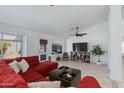 Bright living room with tile floors, white walls, ceiling fan, and backyard access at 3544 E Tonto Ln, Phoenix, AZ 85050