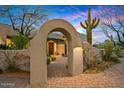 Charming arched entryway with desert landscaping and a brick path leads to the main entrance at 39912 N 98Th Way, Scottsdale, AZ 85262