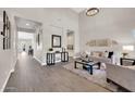 Elegant living room with open floor plan, hardwood floors, and views to kitchen at 4013 N Founder Cir, Buckeye, AZ 85396