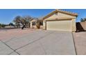 Beige single-story home featuring a two-car garage and a long driveway at 516 N Emery --, Mesa, AZ 85207