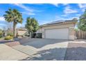 Inviting single-story house with a two-car garage, desert landscaping, and a mature palm tree in the yard at 6071 S Topaz Pl, Chandler, AZ 85249