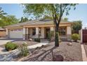 Single-story house shows tile roof, desert landscaping, and covered front porch and two-car garage at 6659 W Oraibi Dr, Glendale, AZ 85308