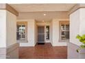 Inviting front porch with tiled flooring, decorative columns, security door, and framed windows for natural light at 6659 W Oraibi Dr, Glendale, AZ 85308