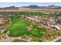 Scenic aerial view of a community surrounding a lush golf course with mountain views at 7201 E Sandia Cir, Mesa, AZ 85207