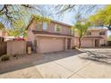 Exterior view of a two story home with a two car garage and desert landscaping at 7650 E Williams Dr # 1011, Scottsdale, AZ 85255