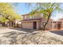 View of a two-story home with a neutral color scheme, large windows, and a two-car garage at 7650 E Williams Dr # 1011, Scottsdale, AZ 85255