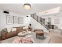 Spacious living room with modern decor, comfortable seating, and a staircase leading upstairs at 7650 E Williams Dr # 1011, Scottsdale, AZ 85255