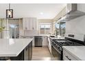 Well-lit kitchen showcasing stainless steel appliances, white cabinets, and a stylish backsplash at 8213 E Fairmount Ave, Scottsdale, AZ 85251