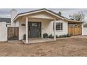 Inviting front porch with stylish gray door, complemented by decorative potted plants and a well-manicured lawn at 8227 N 15Th Pl, Phoenix, AZ 85020