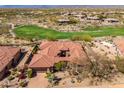 Expansive aerial view of the home with red tile roof, golf course, lush landscaping, and surrounding desert at 9630 E Preserve Way, Scottsdale, AZ 85262