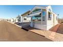 Adorable manufactured home with covered parking, large windows, and low-maintenance desert landscaping at 9736 E Main St # 43, Mesa, AZ 85207