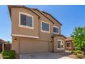 View of a two-story home highlighting the large garage door and a neatly landscaped front yard at 1021 W Vineyard Plains Dr, San Tan Valley, AZ 85143