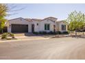 Charming single-story home with a brown tile roof, arched entryway, and a meticulously manicured front yard at 10511 E Diffraction Ave, Mesa, AZ 85212