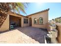 Covered patio with a cozy fireplace, brick pavers, and an outdoor water feature at 12439 W Yellow Bird Ln, Peoria, AZ 85383