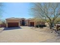 Spacious single-story home featuring a three-car garage and circular driveway with desert landscaping at 13627 E Monument Dr, Scottsdale, AZ 85262