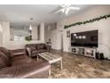 Spacious living room with tile floors, a ceiling fan, and comfortable leather furniture at 1428 W Mesquite Ave, Apache Junction, AZ 85120