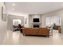 Spacious living room with fireplace, leather sofa, tile flooring, and a view into the dining area at 15050 N Thompson Peak Pkwy # 1035, Scottsdale, AZ 85260