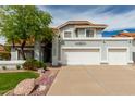 Home exterior featuring a three-car garage and tasteful landscaping, set against a bright sky at 2218 E Mallard Ct, Gilbert, AZ 85234