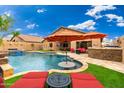 Backyard oasis with a luxurious pool, lounge chairs, and a covered outdoor dining area at 2318 W Hedgehog Pl, Phoenix, AZ 85085