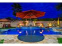Beautiful blue swimming pool at night with a safety fence, lit with a fire display and umbrellas at 2318 W Hedgehog Pl, Phoenix, AZ 85085