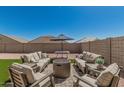 Relaxing outdoor living space with a cozy fire pit and ample seating, perfect for entertaining at 2475 W Spaulding Ave, Apache Junction, AZ 85120