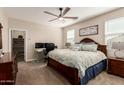 Comfortable primary bedroom features a ceiling fan, plush carpet, and a spacious walk-in closet at 2475 W Spaulding Ave, Apache Junction, AZ 85120