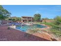 A gorgeous, lush backyard featuring a pool, two-story home, and mature trees and landscaping at 25767 N 67Th Dr, Peoria, AZ 85383