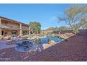 Spacious backyard with large pool, grassy area, desert landscaping, and a two-story house at 25767 N 67Th Dr, Peoria, AZ 85383