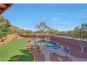 An elevated view of a private backyard with a pool, desert landscaping, and patio area at 25767 N 67Th Dr, Peoria, AZ 85383