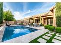 Backyard view of a stunning in-ground pool with travertine tile and lounge chairs to enjoy the beautiful weather at 28834 N 68Th Ave, Peoria, AZ 85383