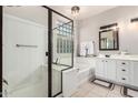 Well-lit bathroom featuring a glass-enclosed shower, soaking tub, and dual sink vanity with storage at 29794 N Little Leaf Dr, San Tan Valley, AZ 85143