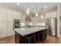 Elegant kitchen featuring a center island with bar seating, stainless steel appliances, and stylish pendant lighting at 3353 E Nolan Dr, Chandler, AZ 85249