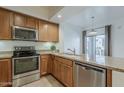 Kitchen featuring stainless steel appliances, wooden cabinetry, and granite countertops at 3935 E Rough Rider Rd # 1264, Phoenix, AZ 85050