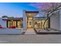 Stylish modern home with desert landscaping and a sleek entryway and modern front door at 5033 E Turquoise Ave, Paradise Valley, AZ 85253