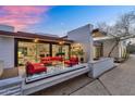 Cozy outdoor patio with modern red furniture, gas fireplace, and view into the living room at 5033 E Turquoise Ave, Paradise Valley, AZ 85253