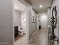 Hallway featuring tile floors, neutral paint, a decorative mirror, and access to a bathroom at 5450 E Deer Valley Dr # 1186, Phoenix, AZ 85054